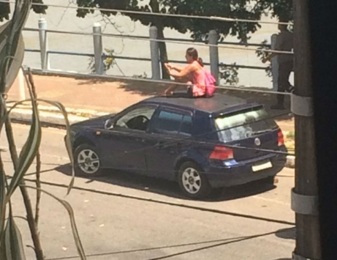 Mulher sobe em carro para evitar reboque
