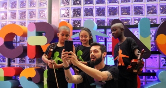 Crianças da Orquestrando a Vida posam com o jornalista Cauê Fabiano