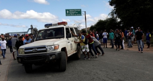 Ambulncia que transportava pessoas feridas durante confrontos no sul da cidade venezuelana de Kumarakapay, perto da fronteira com o Brasil,  assistida por pessoas na fronteira entre a Venezuela e o Brasil, em Pacaraima.