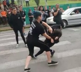 Jovens brigam em frente à escola