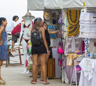 Turistas compram peças de artesanato na Praia dos Cavaleiros