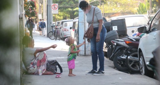 Criança com a mãe pede dinheiro na rua