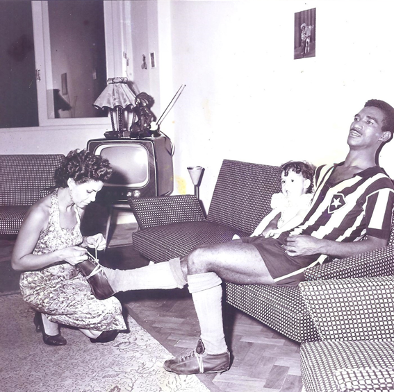 Álbum de família. Guiomar descalça as chuteiras  de um extenuado Didi, campeão carioca pelo Botafogo. Rebeca, então com dois anos, se delicia com a cena