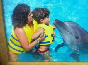 Cludia Boechat, o filho Dani e um raro beijo em um golfinho. 