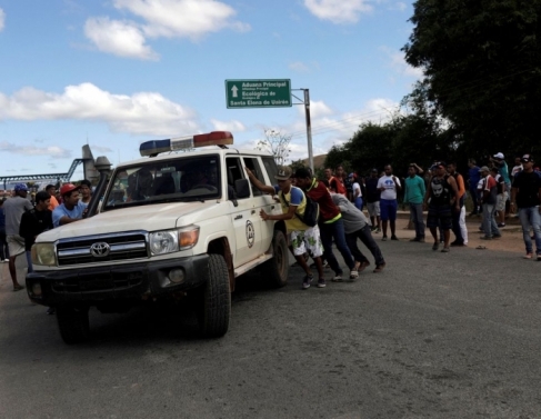 Ambulância que transportava pessoas feridas durante confrontos no sul da cidade venezuelana de Kumarakapay, perto da fronteira com o Brasil, é assistida por pessoas na fronteira entre a Venezuela e o Brasil, em Pacaraima.
