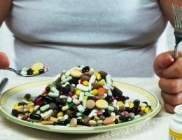 Overweight man eating plate full of pills