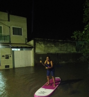 Moradora usa prancha de stand up paddle na rua