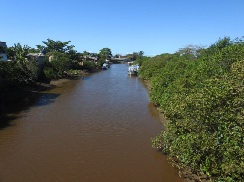 Canal Engenheiro Antonio Resende na mar&eacute; baixa. Margem direita ocupada por mangue; margem esquerda ocupada por habita&ccedil;&otilde;es de baixa renda