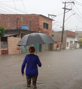 Senhora em rua alagada em Custod&oacute;polis