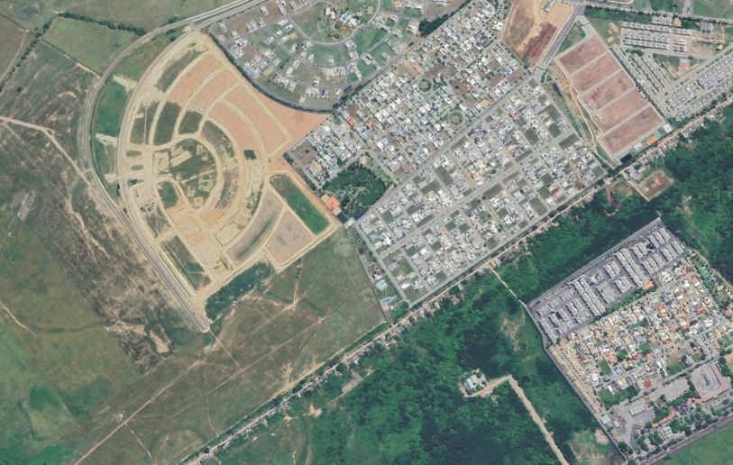 Área de implantação de condomínios de alta renda e comunidade Margem da Linha, em Campos dos Goytacazes – separados por vegetação, terrenos vazios e muros. 