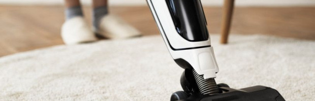 Vacuum cleaning a rug on the floor