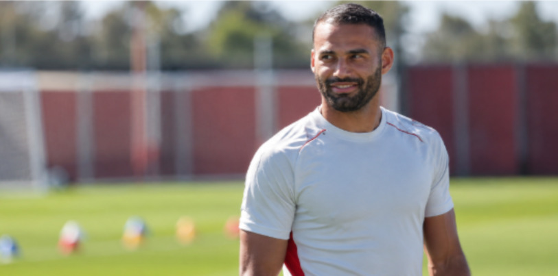 Alt: Jogador de futebol em um campo de treinamento
